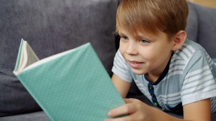 Child reading in bed past bedtime